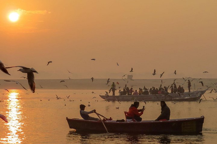 Pilgrims and boats along the ghats of Varanasi on the Ganges in early morning light